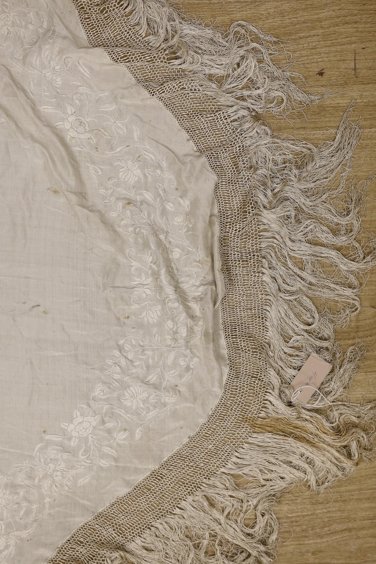 A late 19th/early 20th century Chinese cream silk shawl with cream silk embroidery and fringing, converted to a ladies cape